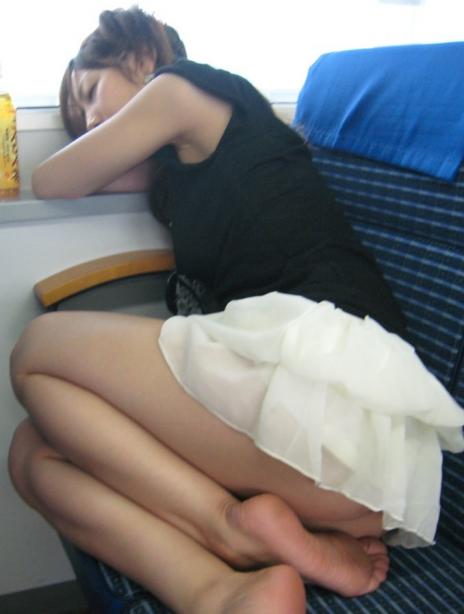 足裏見せて列車で眠りこける女性