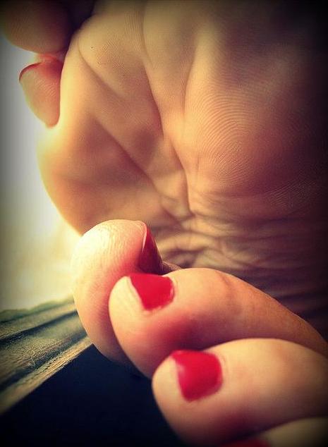 赤いペディキュアと足裏の指紋