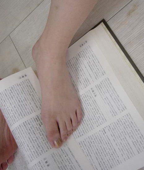 足で本を開く女性の爪先