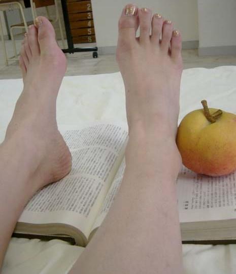 足で本を開く女性の爪先
