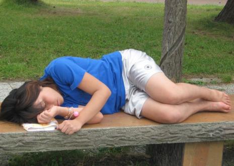 生足をさらけ出してベンチに眠る女学生